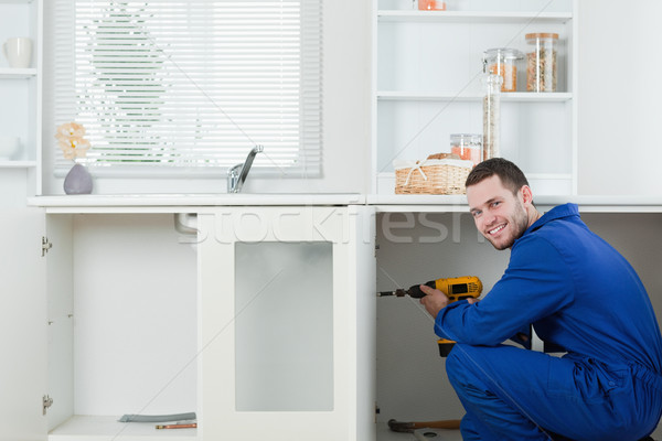 Smiling handyman fixing a door in a kitchen Stock photo © wavebreak_media