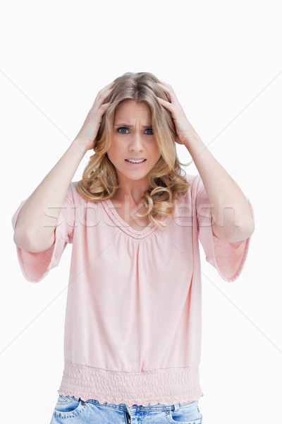 A frustrated woman has her hands held up to her head against a white background Stock photo © wavebreak_media