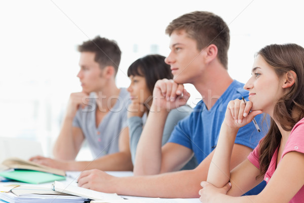 Stock photo: A side view of a group of students thinking with hands on their chins 