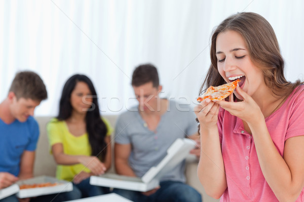 Femme souriante manger pièce pizza amis s'asseoir [[stock_photo]] © wavebreak_media