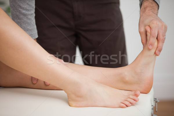 Chiropodist touching the foot of a patient in a room Stock photo © wavebreak_media
