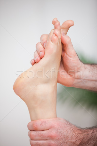 Doctor massaging the foot of his patient in a room Stock photo © wavebreak_media