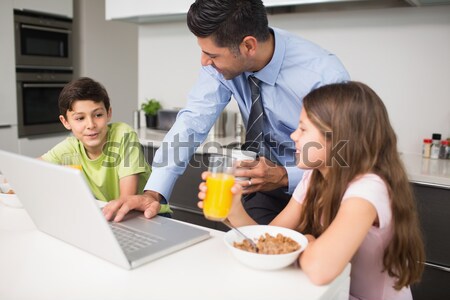 Kids with parents having breakfast in kitchen Stock photo © wavebreak_media