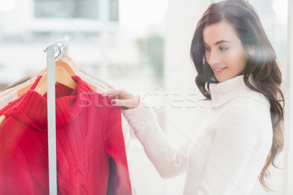 Pretty brunette looking at clothes on rail Stock photo © wavebreak_media