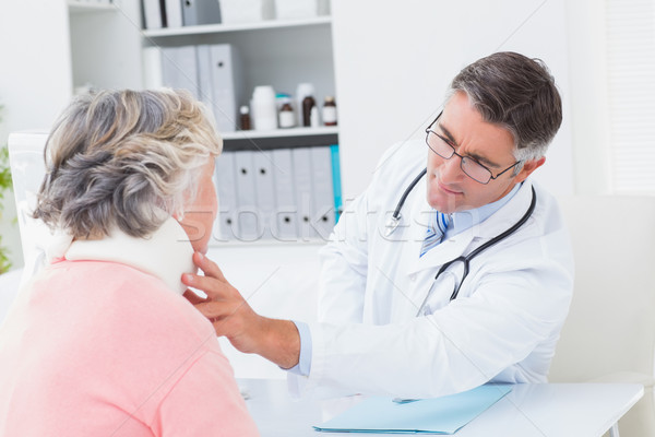 Doctor examining female patient wearing neck brace Stock photo © wavebreak_media