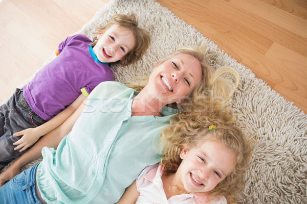 Happy mother and children lying on rug Stock photo © wavebreak_media