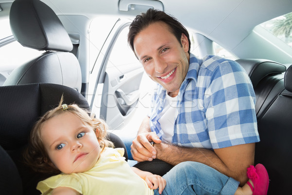 Stock photo: Father securing his baby in the car seat