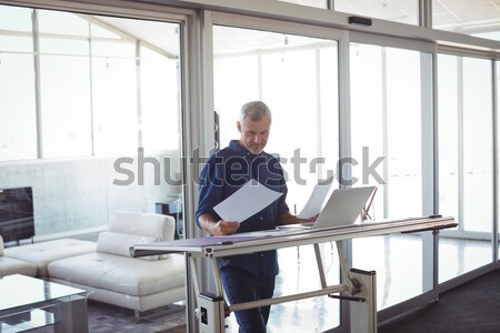 Stock photo: Technician sitting on swivel chair using laptop to diagnose serv