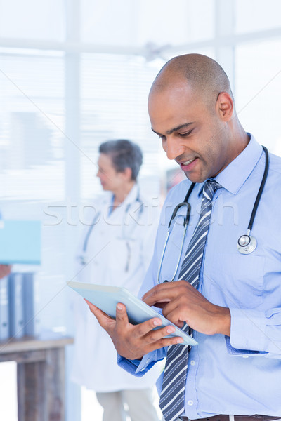 Smiling doctor using his tablet Stock photo © wavebreak_media