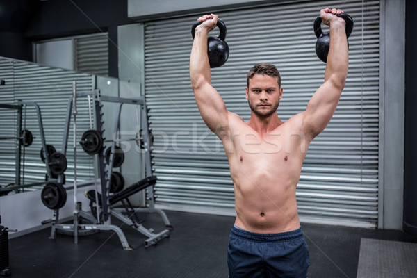 Portrait of muscular man lifting two kettlebells Stock photo © wavebreak_media