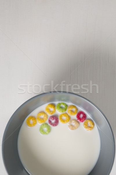 Stock photo: Bowl of milk and cereal rings on white background