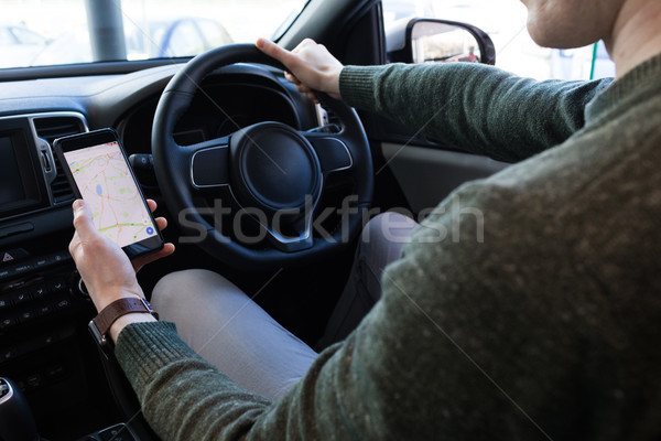 Homme smartphone conduite voiture regarder carte [[stock_photo]] © wavebreak_media