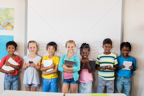 [[stock_photo]]: Souriant · élèves · permanent · technologie · classe · heureux