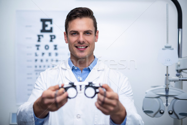 Smiling optometrist holding messbrille Stock photo © wavebreak_media