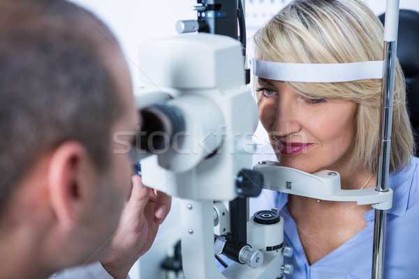 Stock photo: Optometrist examining female patient on slit lamp