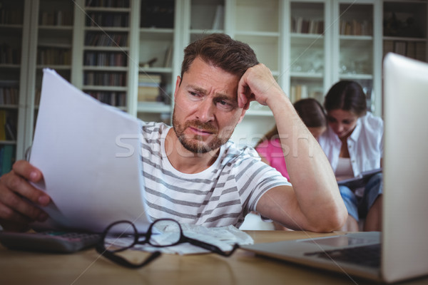 Worried man calculating bills while his wife and daughter sitting on sofa Stock photo © wavebreak_media