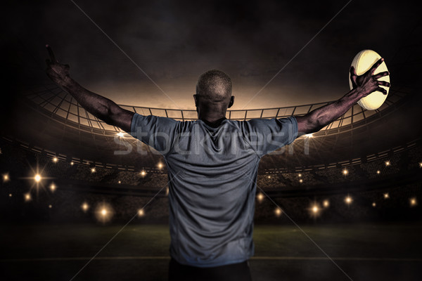 Composite image of rear view of sportsman with arms raised holdi Stock photo © wavebreak_media