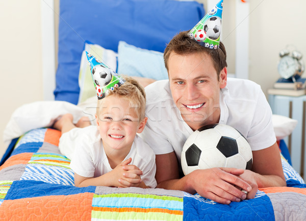 Happy child and his father playing with a soccer ball Stock photo © wavebreak_media