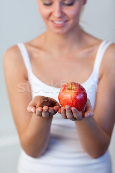 Beautiful woman holding chocolate and apple focus on apple  Stock photo © wavebreak_media