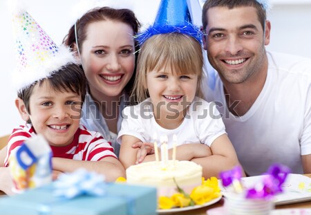Little girl blowing out candles in her birthday with her family Stock photo © wavebreak_media