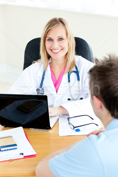 Sorridere femminile medico utilizzando il computer portatile parlando maschio Foto d'archivio © wavebreak_media