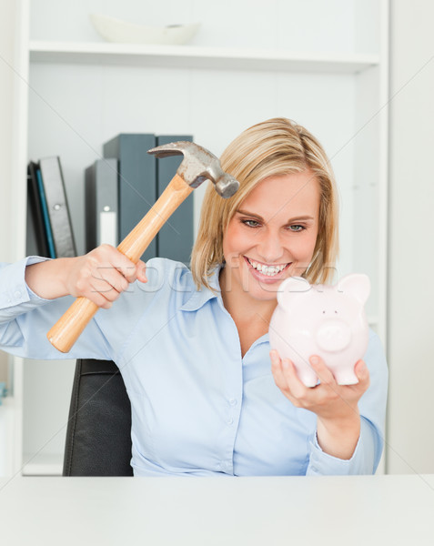 Smiling woman wanting to destroy her piggy bank in her office Stock photo © wavebreak_media