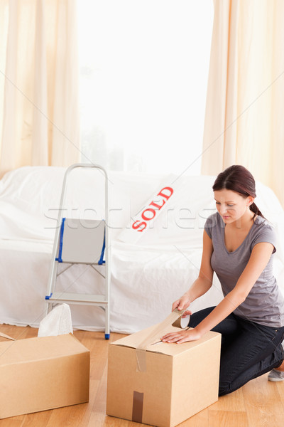 A woman is packing cardboards in the living room Stock photo © wavebreak_media