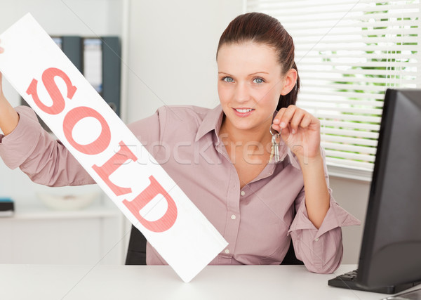 A businesswoman shows a sold sign in her office Stock photo © wavebreak_media