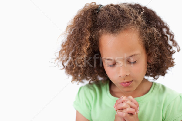 Stock photo: Cute girl praying against a white background