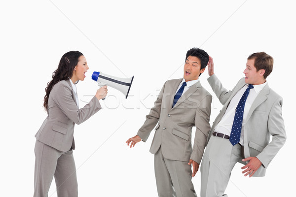 Businesswoman with megaphone yelling at colleagues against a white background Stock photo © wavebreak_media