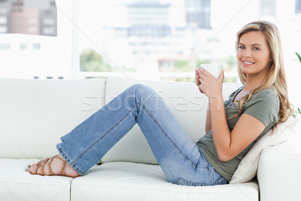 Stock foto: Frau · Sitzung · Couch · schauen · vorwärts · lächelnd