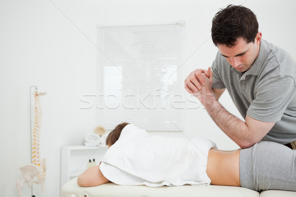 Brunette physiotherapist massaging a woman with his elbow in a room Stock photo © wavebreak_media