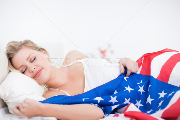 Blonde woman sleeping with a US flag on her bed Stock photo © wavebreak_media
