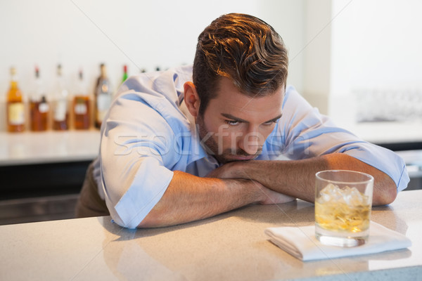 Drunk businessman looking at his whiskey glass after work Stock photo © wavebreak_media