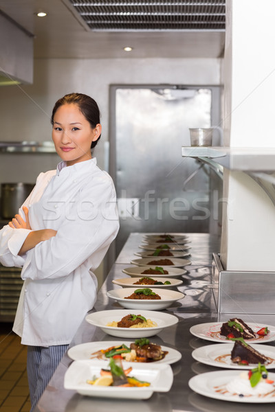 Stock photo: Confident chef besides cooked food in row at kitchen