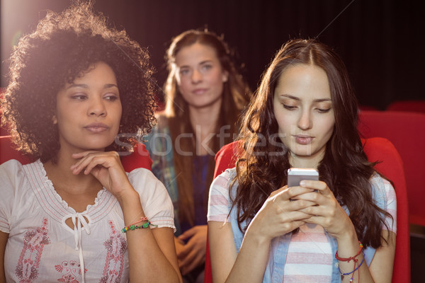 Annoying woman texting during movie Stock photo © wavebreak_media