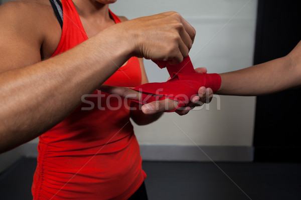 Trainer tying hand wrap on woman hand Stock photo © wavebreak_media