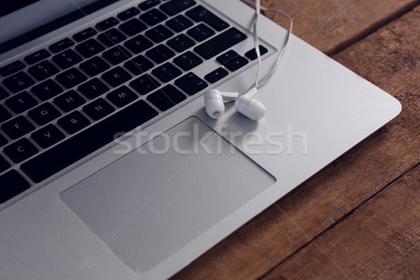 Stock photo: Close-up of earphones on laptop at wooden table