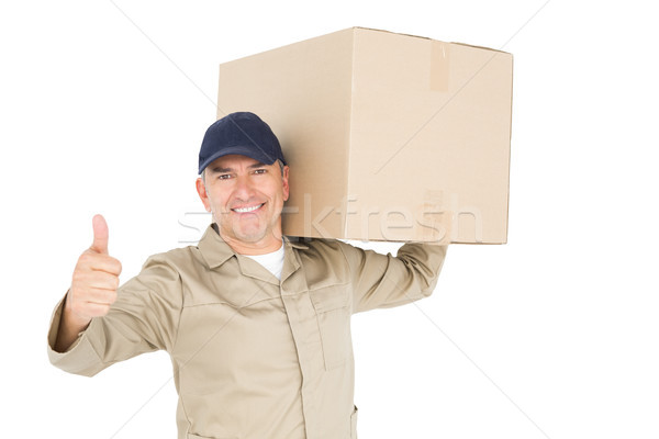 Delivery man carrying a package and showing a thumbs up Stock photo © wavebreak_media