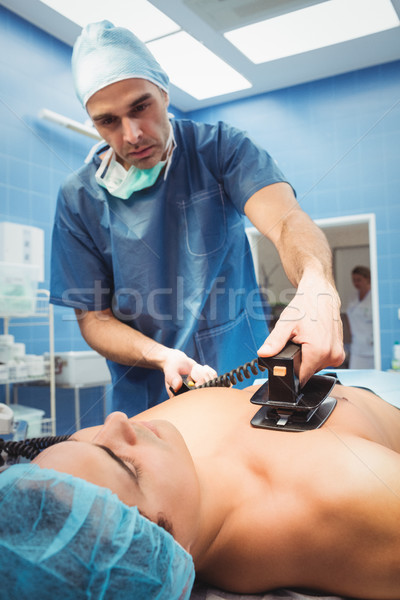 Male surgeon resuscitating an unconscious patient with a defibri Stock photo © wavebreak_media