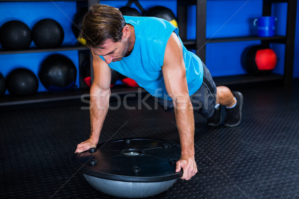 Young man with BOSU ball in gym Stock photo © wavebreak_media