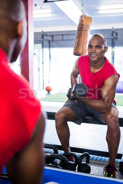 Férfi mosolyog testmozgás súlyzók tükröződés fitnessz Stock fotó © wavebreak_media
