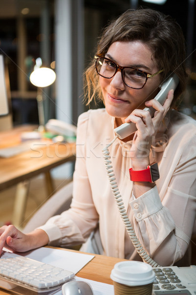 Zakenvrouw praten telefoon werken computer bureau Stockfoto © wavebreak_media