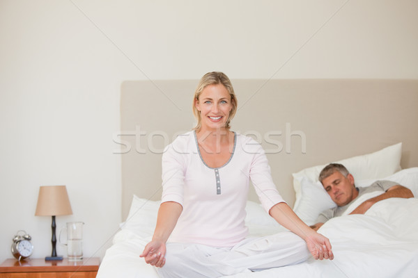 Lovely woman practicing yoga on her bed Stock photo © wavebreak_media