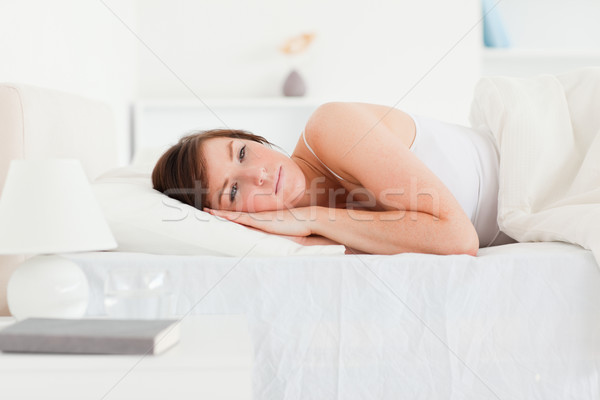 Brünette weiblichen Denken Bett Lächeln Gesicht Stock foto © wavebreak_media