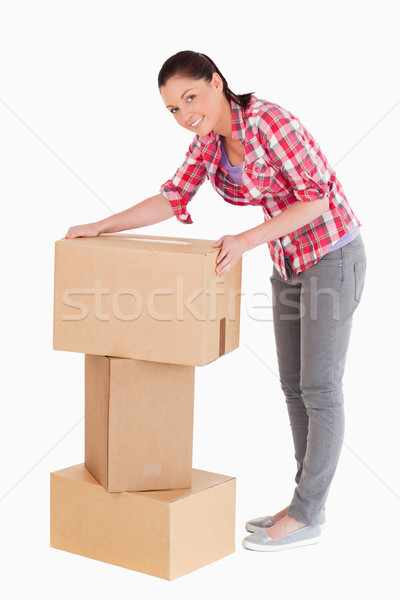 Good looking woman posing with cardboard boxes while standing against a white background Stock photo © wavebreak_media