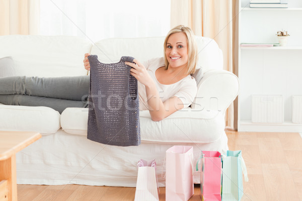 Stock photo: Woman holding the clothes she bought while looking at the camera