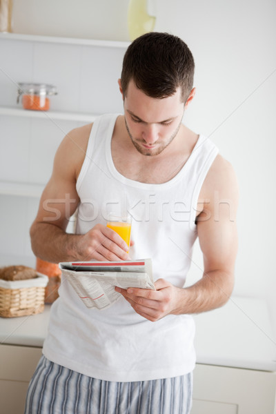 Portrait of a man reading the news while drinking orange juice in his kitchen Stock photo © wavebreak_media