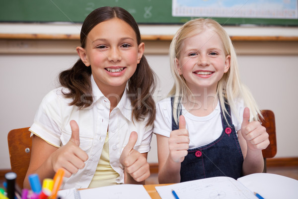Portrait of happy pupils working together with the thumbs up in a classroom Stock photo © wavebreak_media