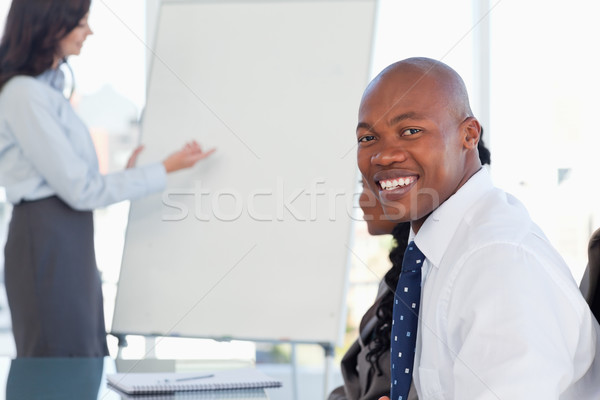 Young smiling executive wearing a white shirt and sitting at a desk in a meeting room Stock photo © wavebreak_media